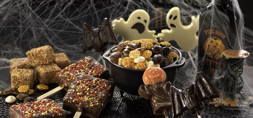Halloween candy arranged in a dark, spooky scene. 