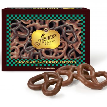 Assorted Chocolate Covered Pretzel Box sits on white background. Three (3) three ring pretzel twists sit in front of box to reveal size and texture of milk and dark pretzels.