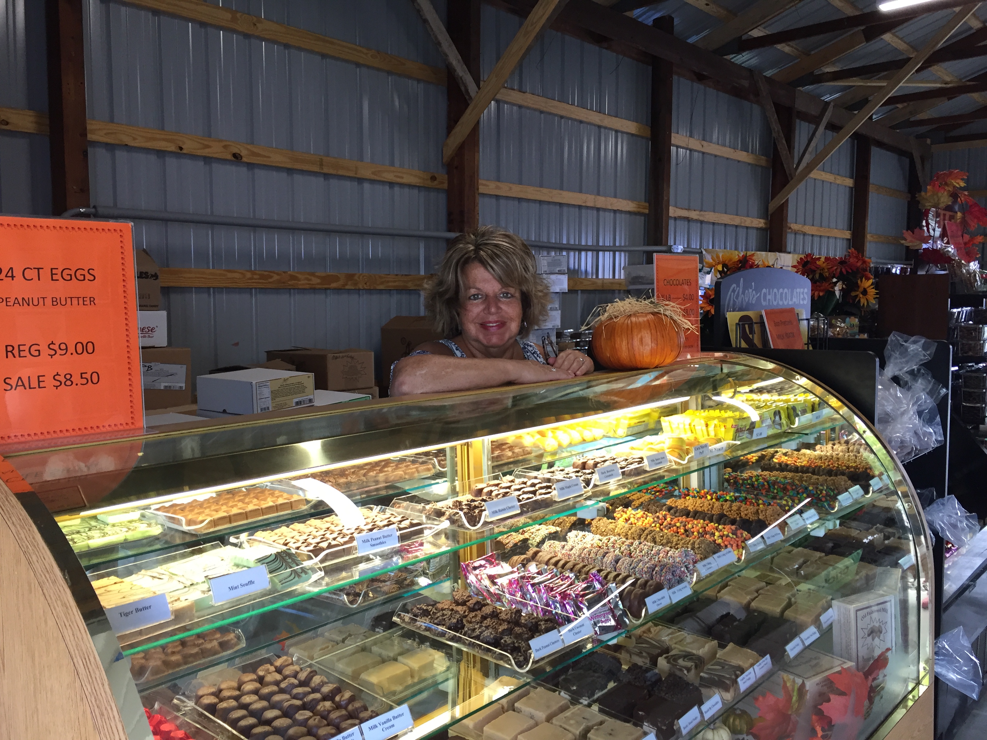 Val Edmiston, employee highlight, smiles and poses at the Asher's Chocolate Co. booth at the Centre County Grange Fair. 